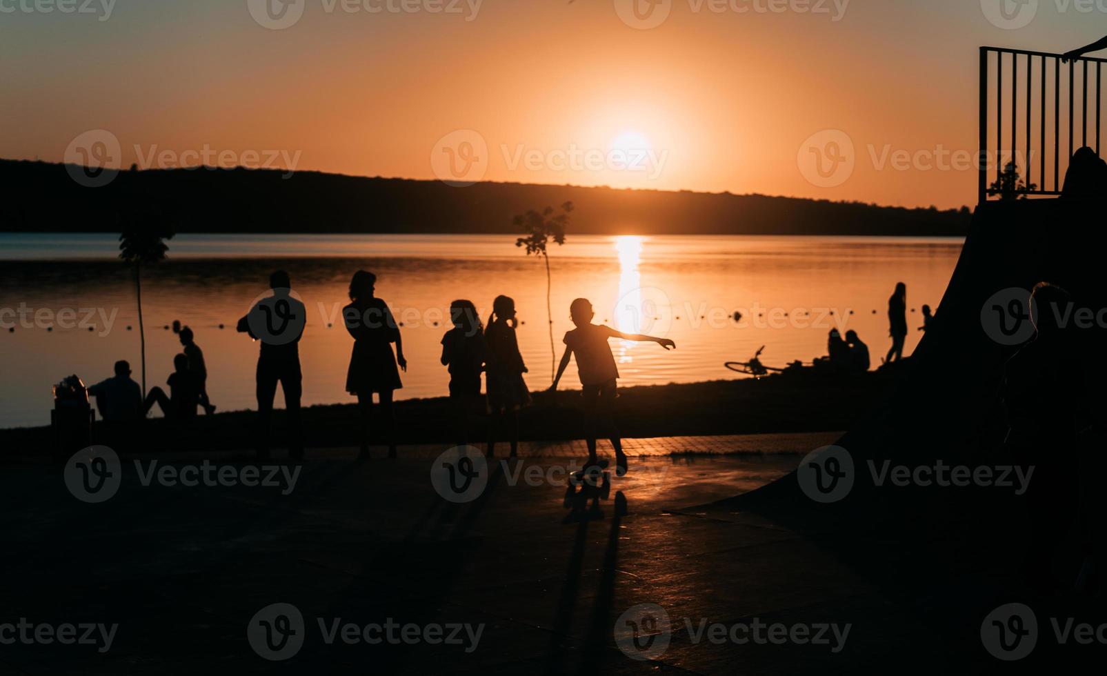 people are resting on a sports field by the river bank photo