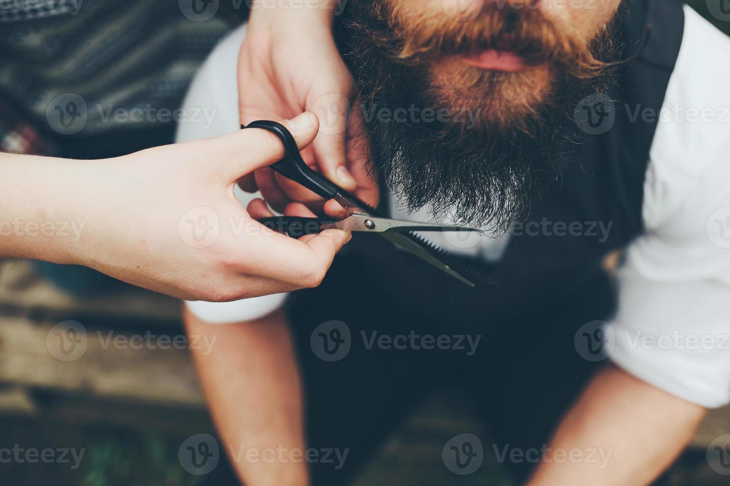 barber shaves a bearded man photo
