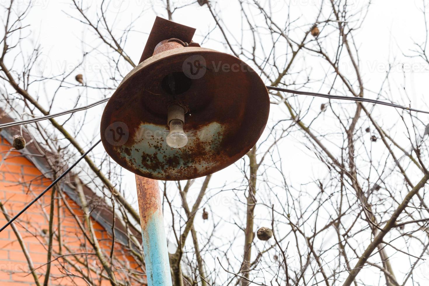 rusty lantern with electric light bulb in spring photo