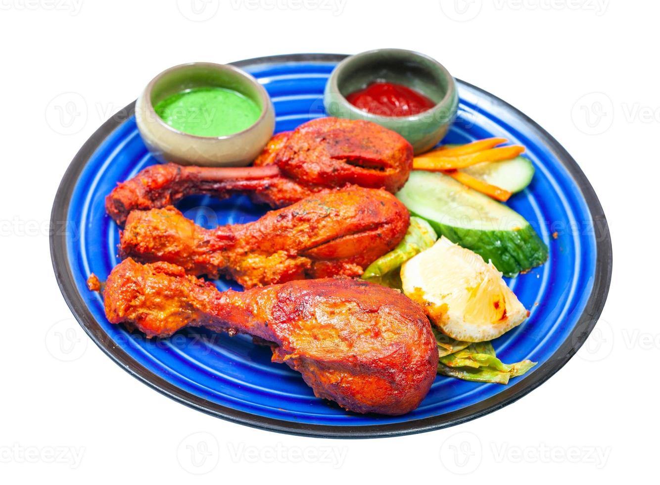 cooked Tandoori chicken on blue plate isolated photo