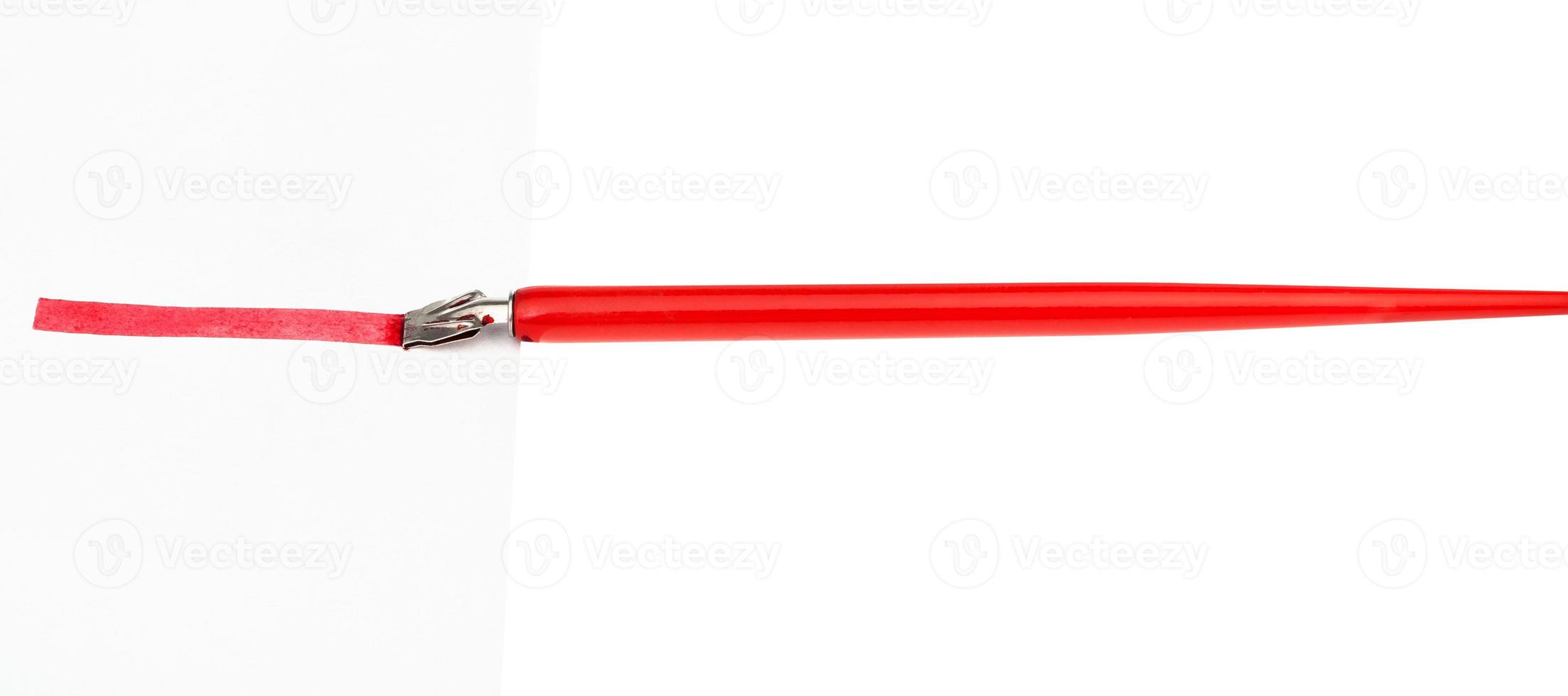 side view of dip pen drawing red line by wide nib photo