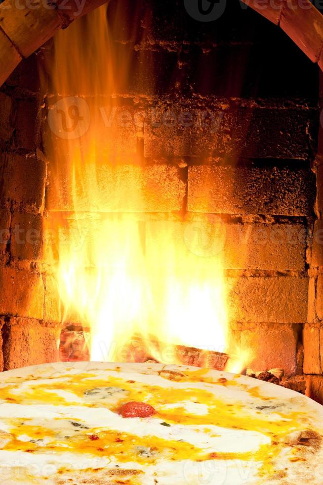 pizza quatro formaggi and fire flames in oven photo