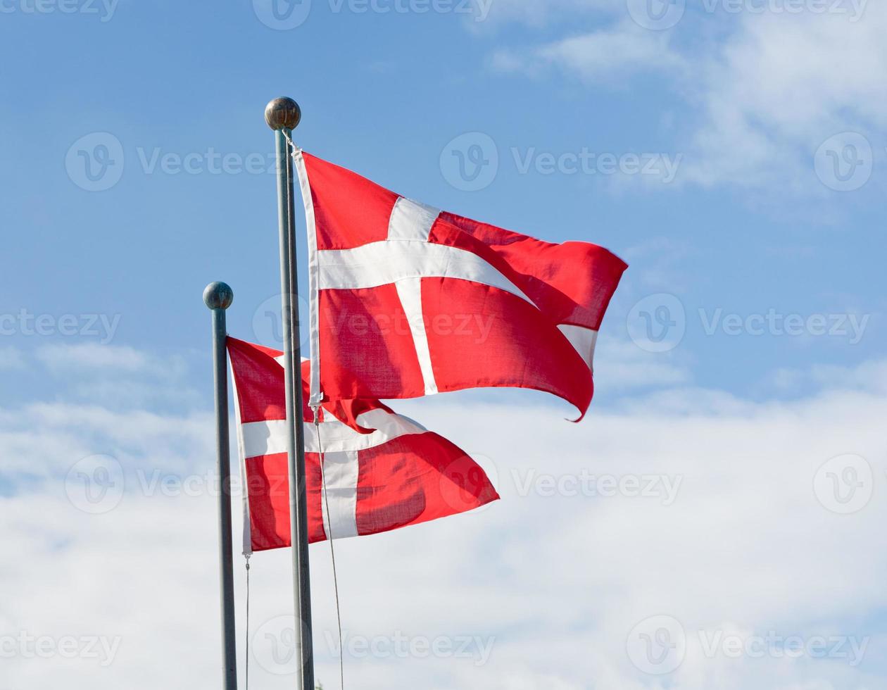 danish flags and white clouds in blue sky photo