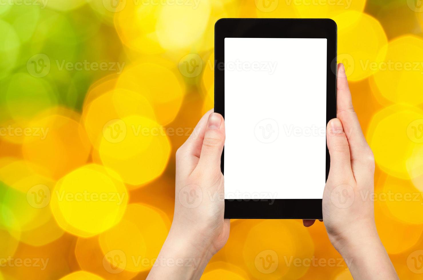 hand with tablet pc on yellow and green background photo