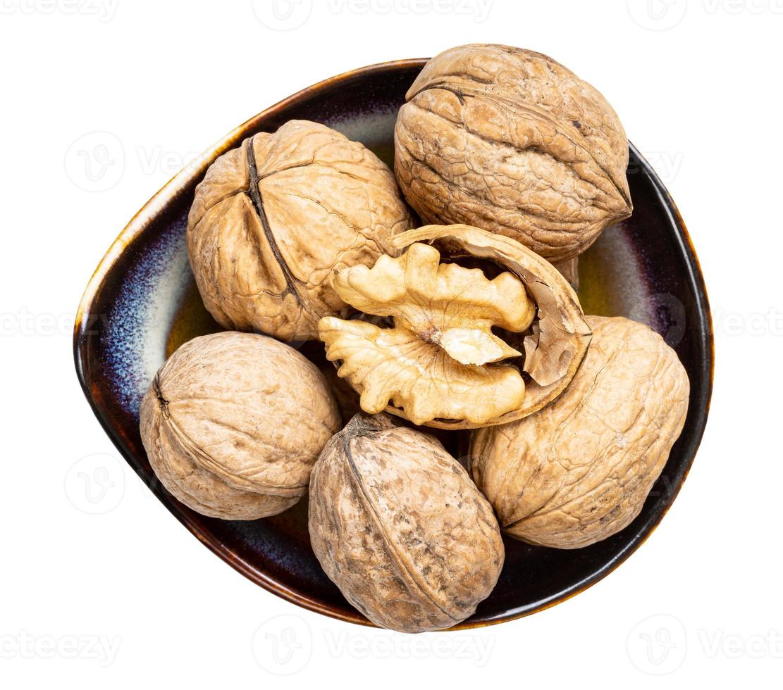 top view of shelled and few whole walnuts in bowl photo