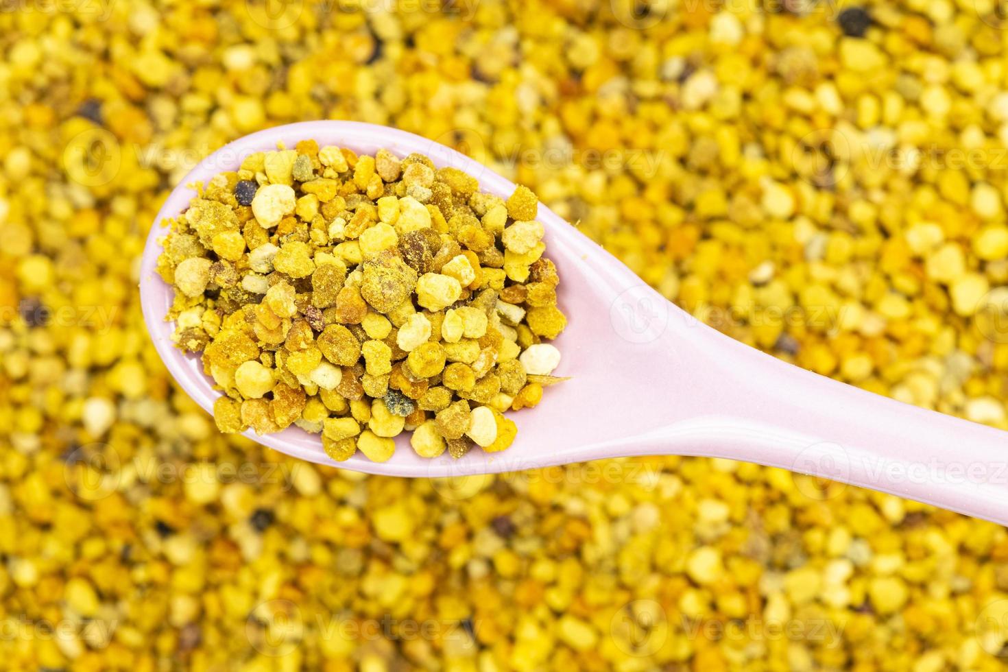 spoon with bee pollen over bee bread on background photo