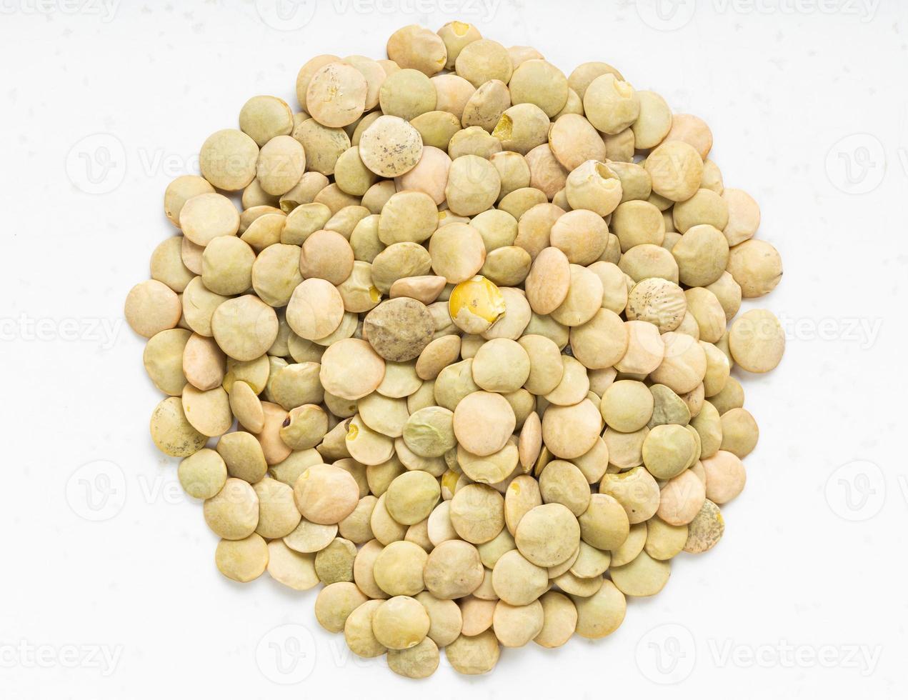 pile of raw light green lentils close up on gray photo