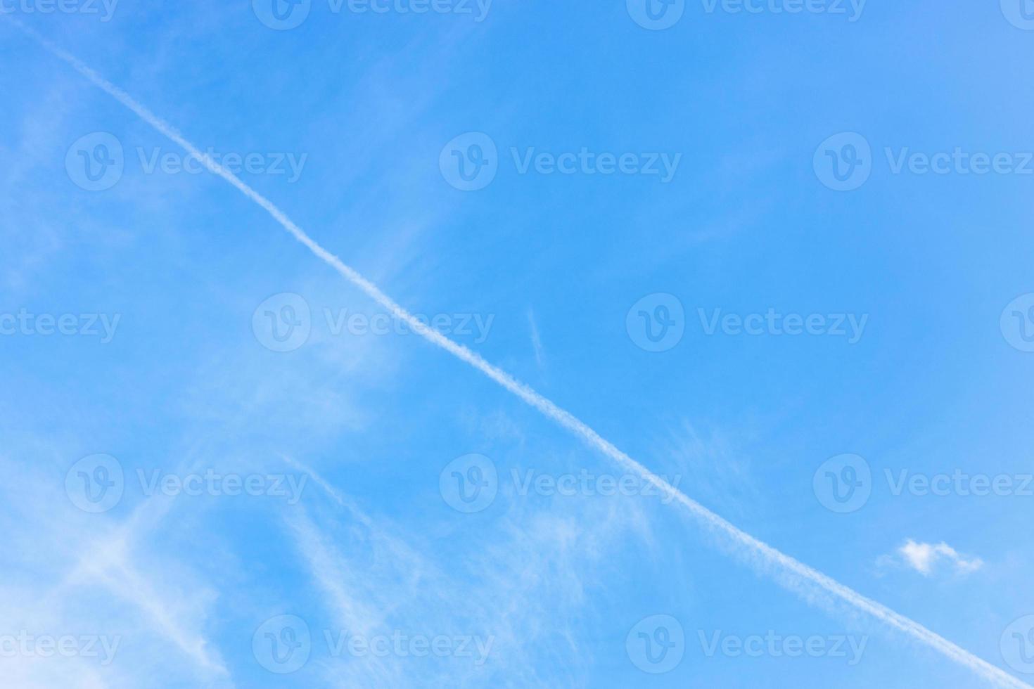 contrail and cirrus clouds in blue sky photo