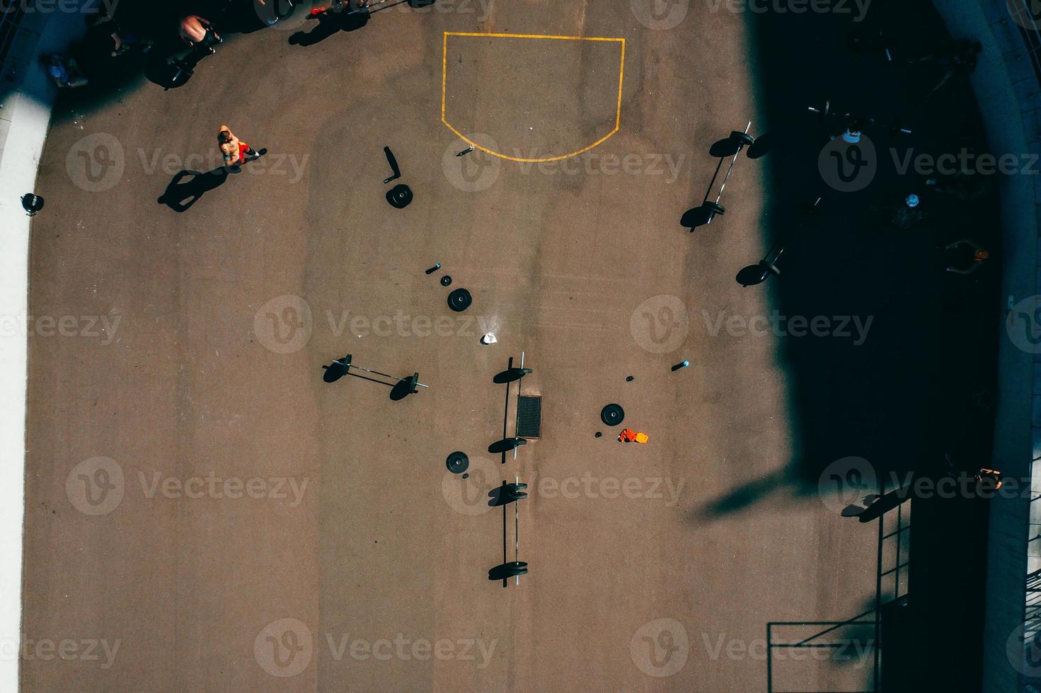 imágenes aéreas de un campo de deportes, gente haciendo levantamiento de pesas foto