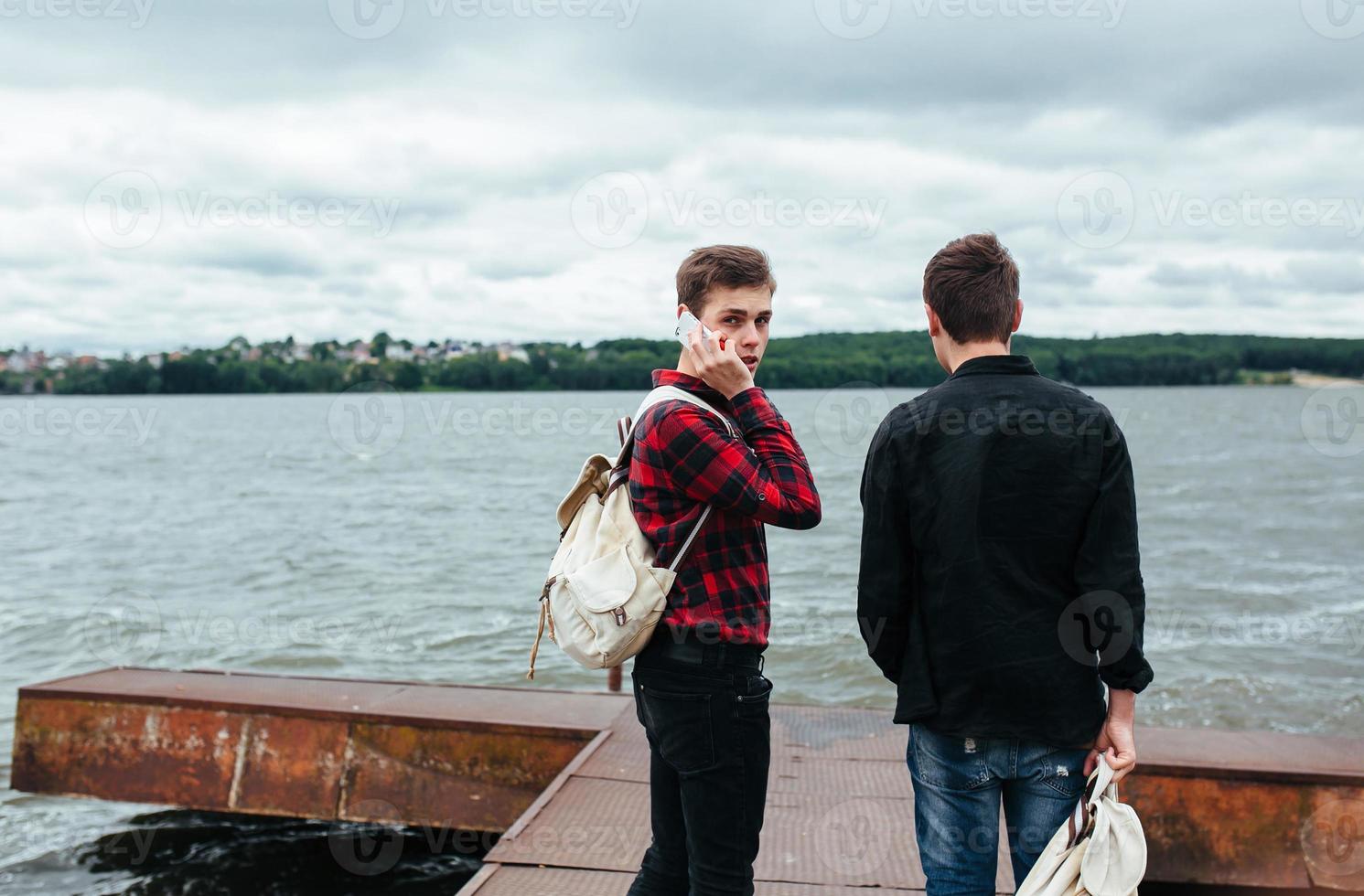 two young guys stand on the pier photo