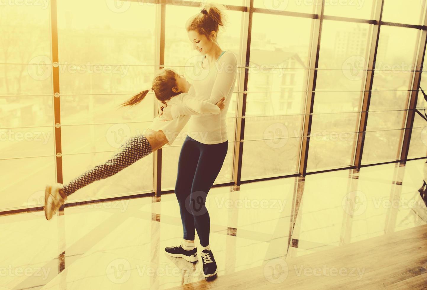 Mother twist her daughter in the gym photo