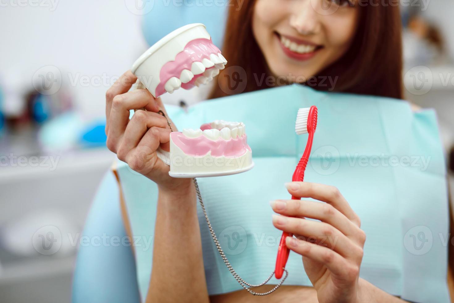Chica con cepillo de dientes en la mano y dientes foto