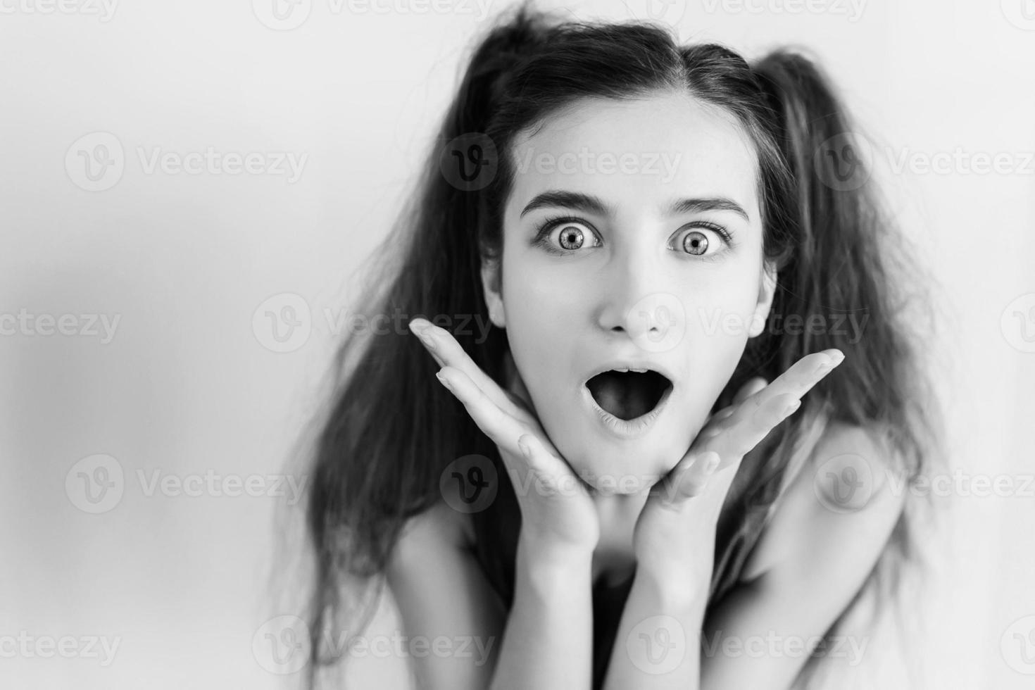 Surprised young girl with pigtails photo