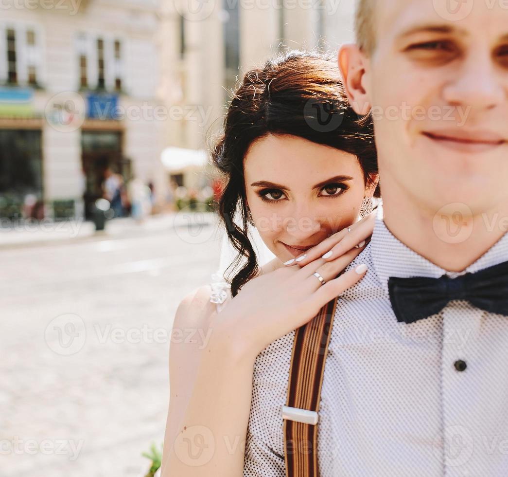 Bride embraces bridegroom photo