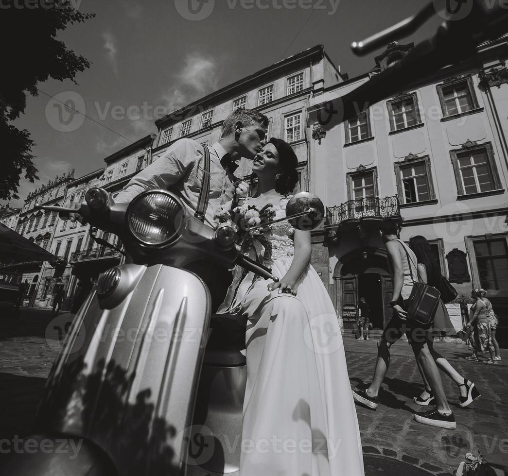 bride and groom on vintage motor scooter photo