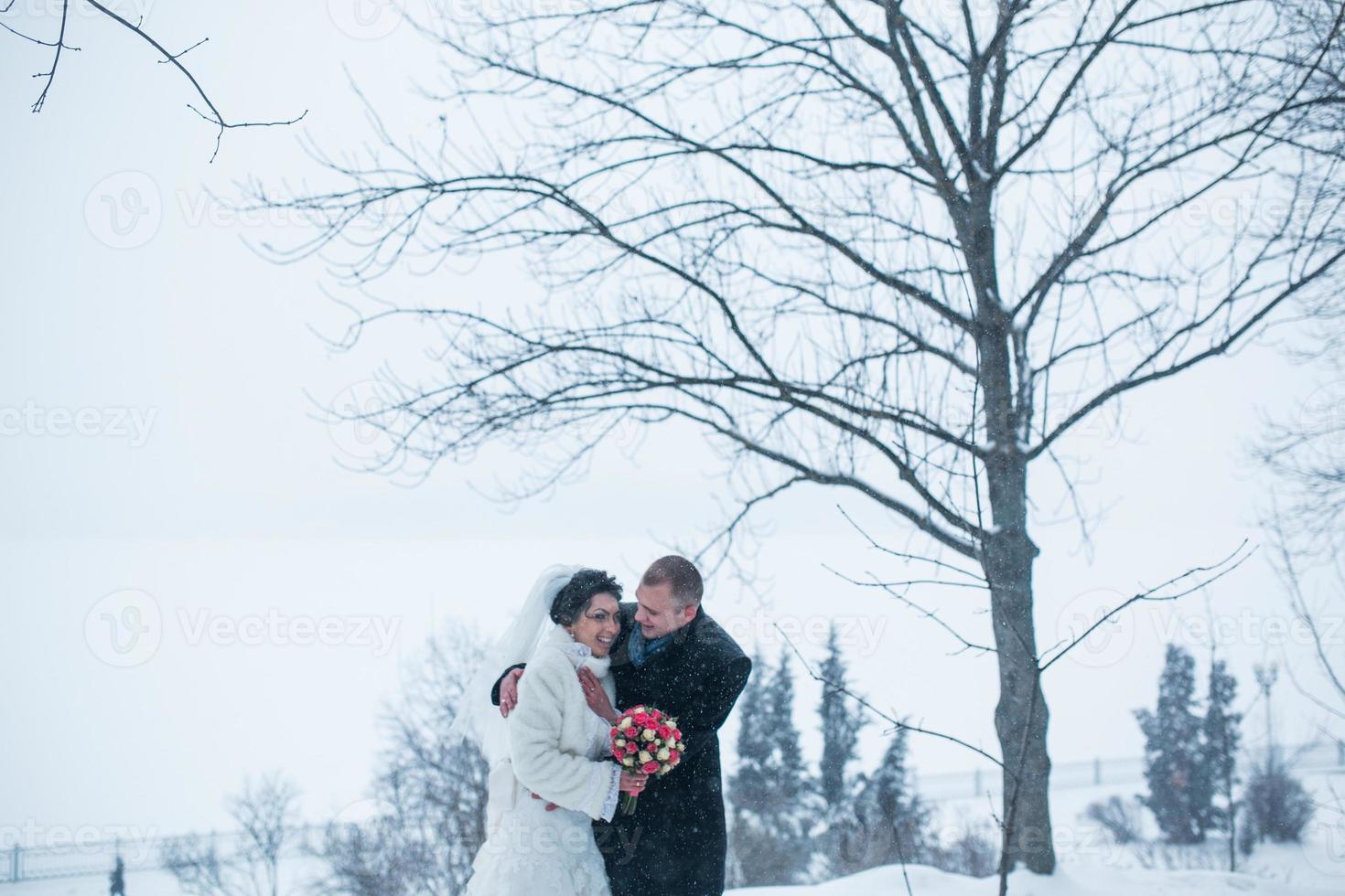 Bride and groom walking on the European city in the snow photo