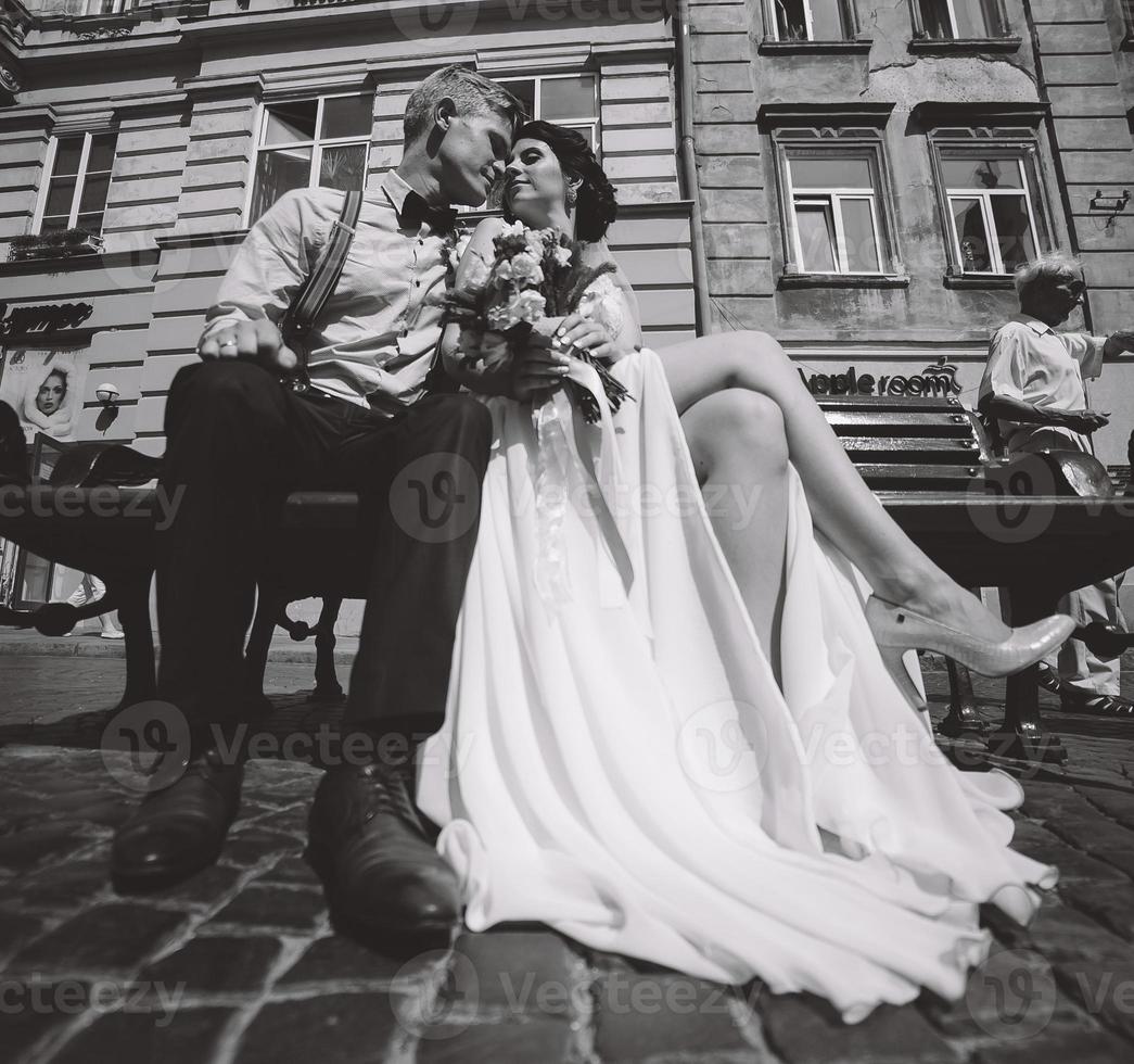 bride and groom sit on the bench photo