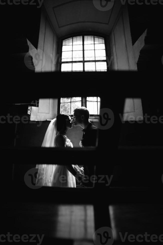 bride and groom on the background of a window. photo