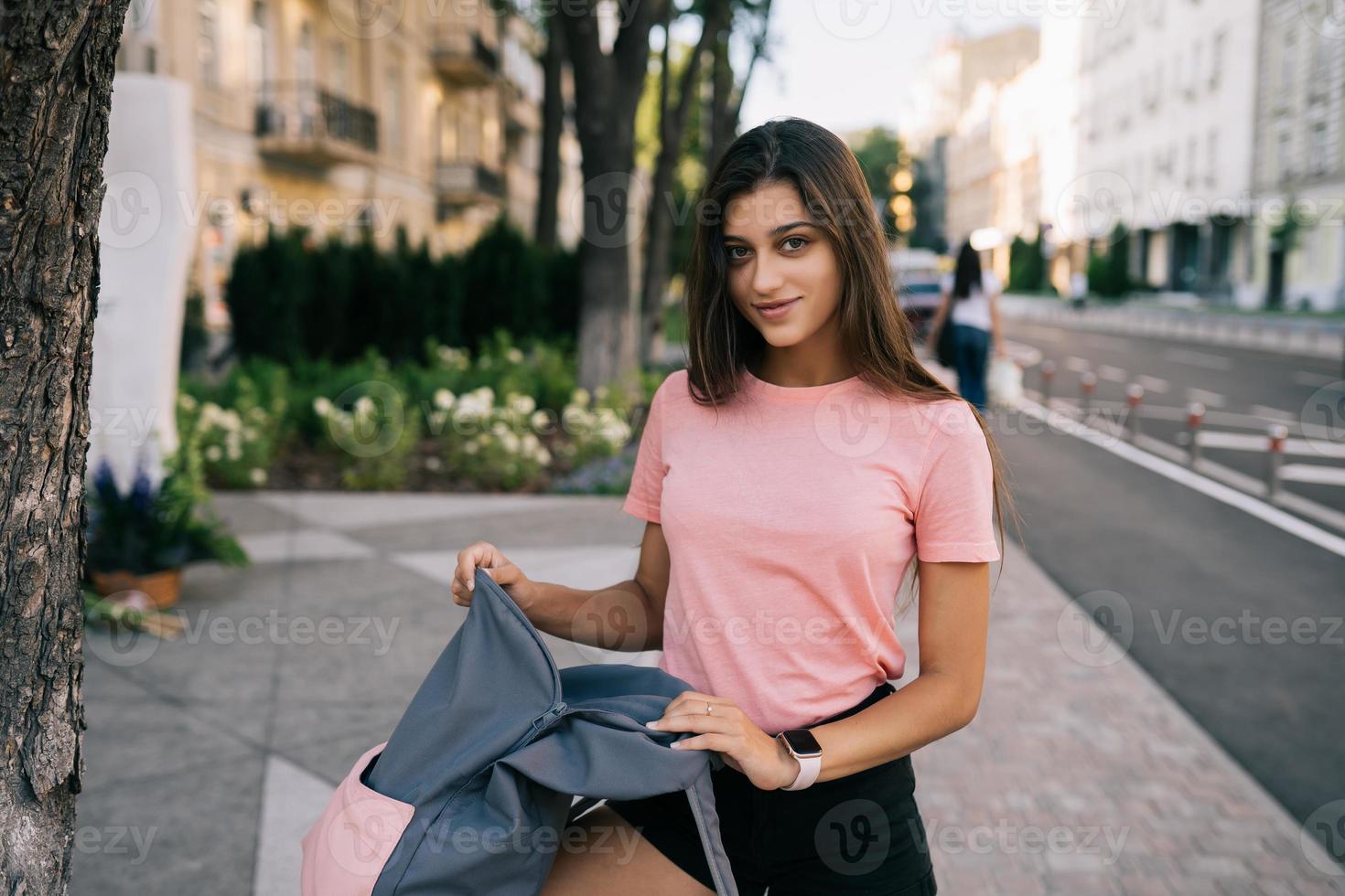 mujer joven con mochila abierta en la calle foto