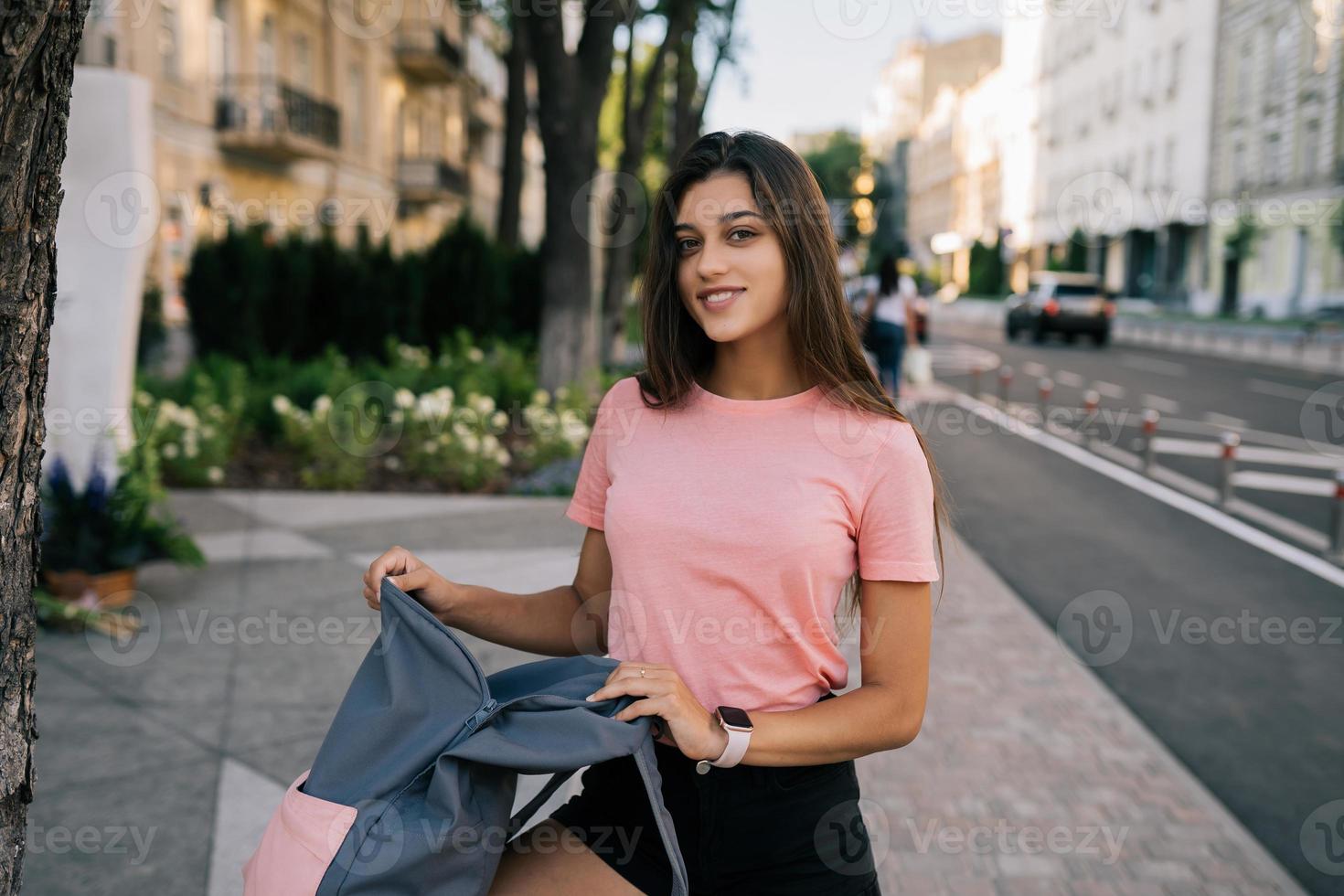 Young woman with open backpack on the street photo