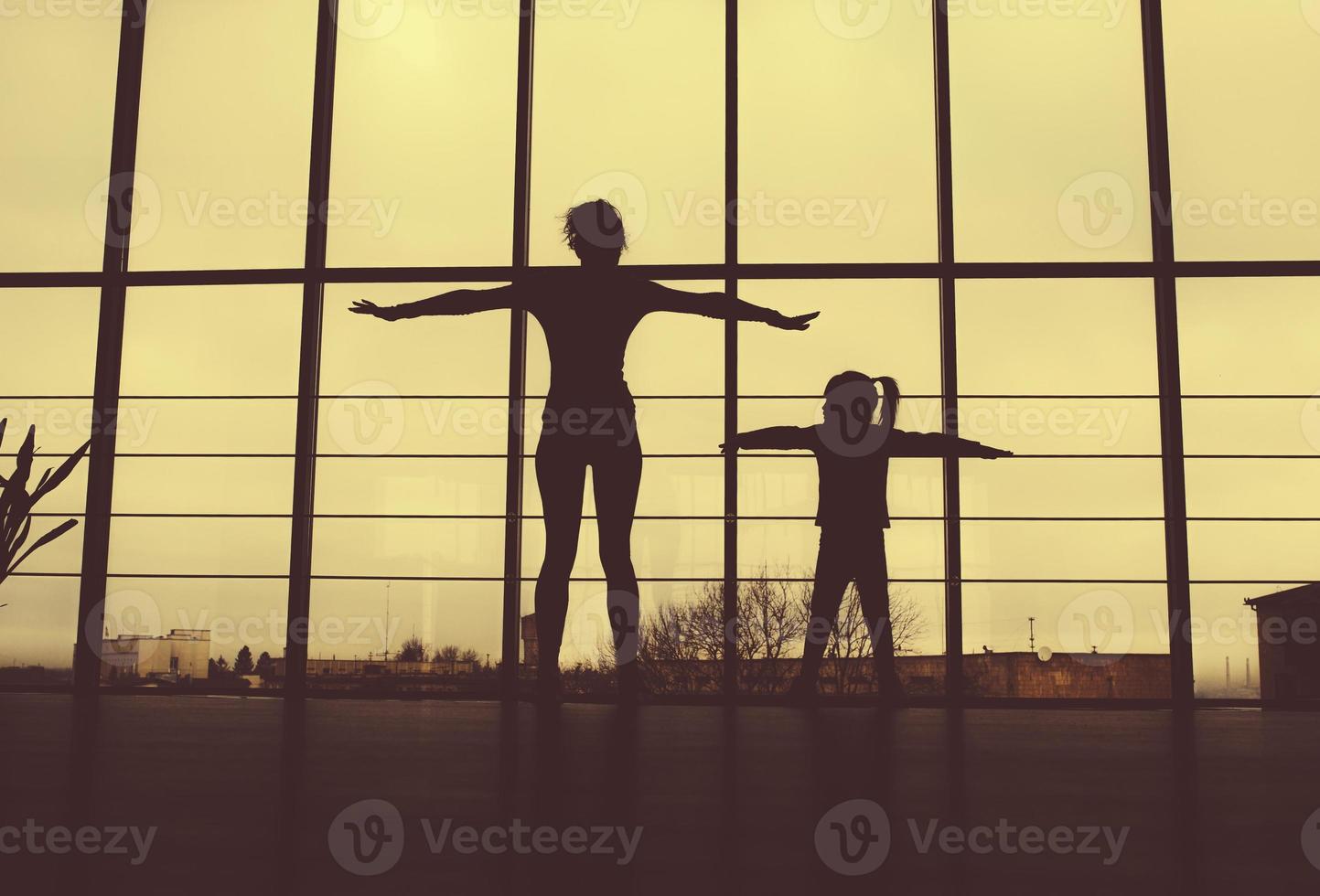 silueta de madre e hija en el gimnasio foto