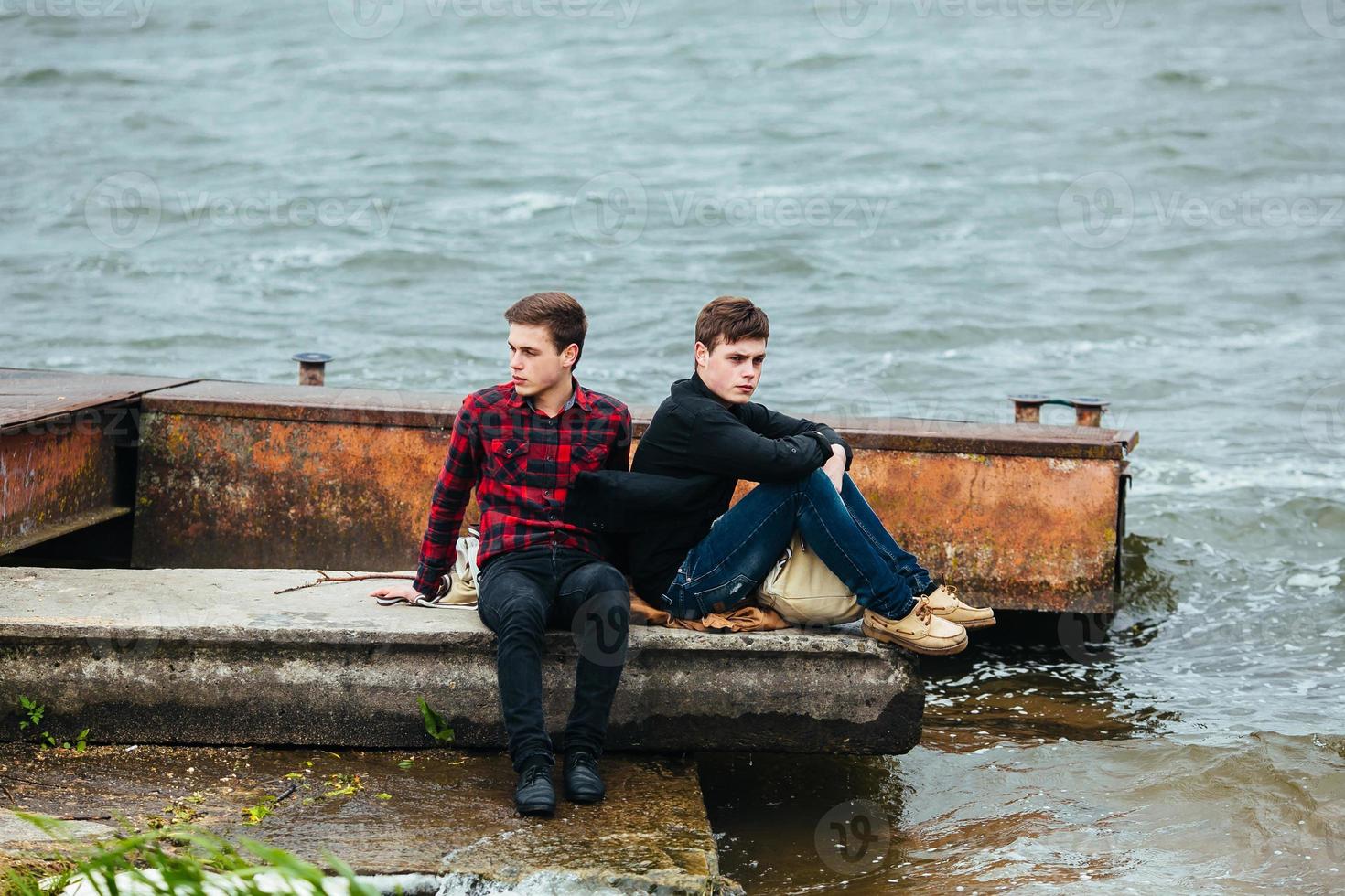 Two friends relaxing on the pier. photo