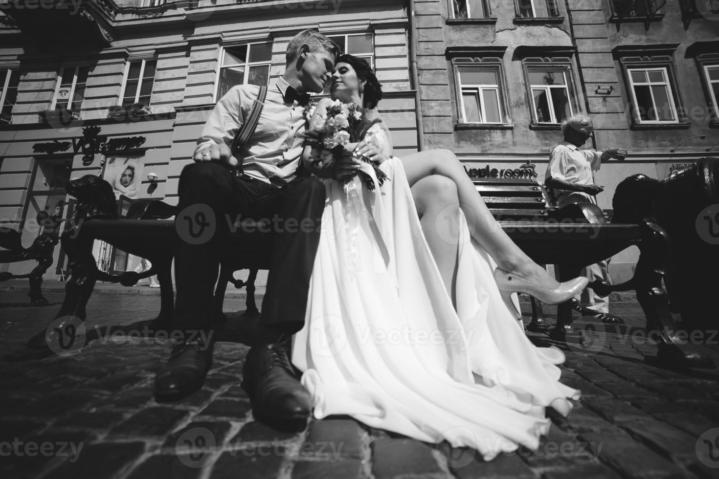 bride and groom sit on the bench photo