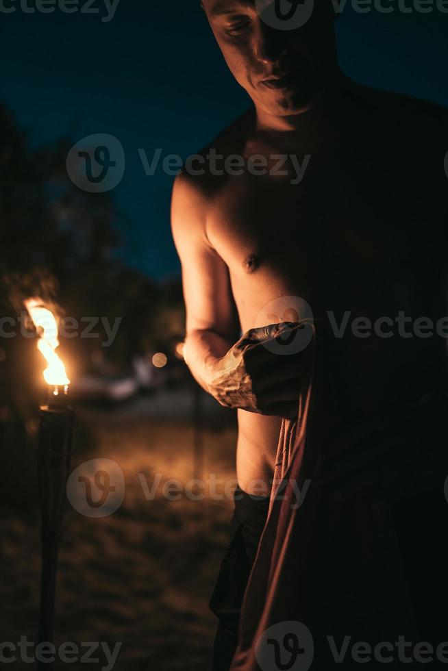 Guy with torchlight on the beach at night photo