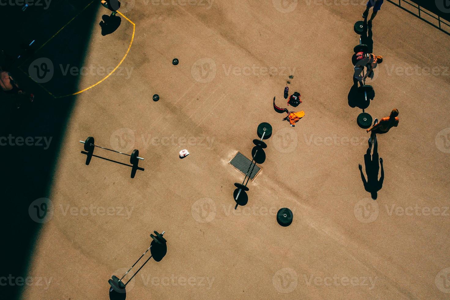 imágenes aéreas de un campo de deportes, gente haciendo levantamiento de pesas foto