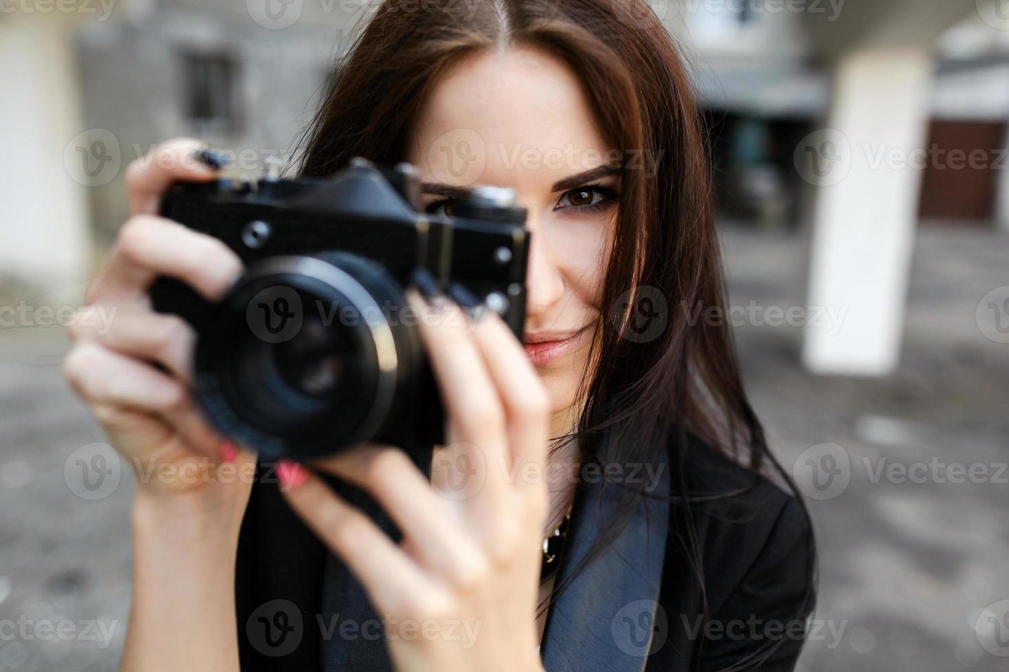 Beautiful female photographer posing with camera photo