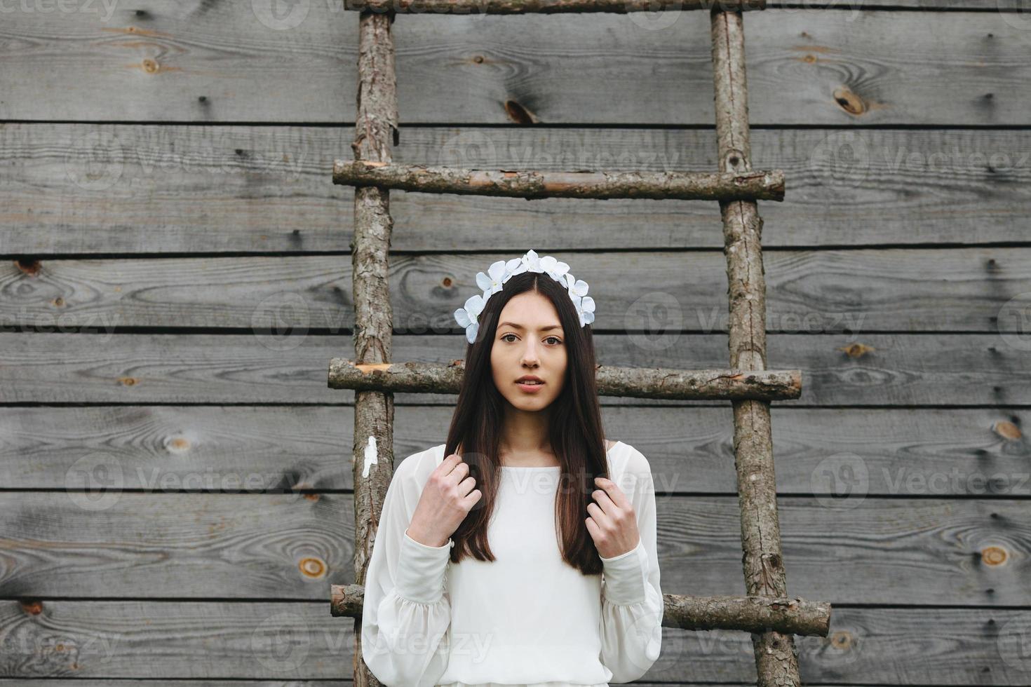 Lovely girl near a wooden house photo