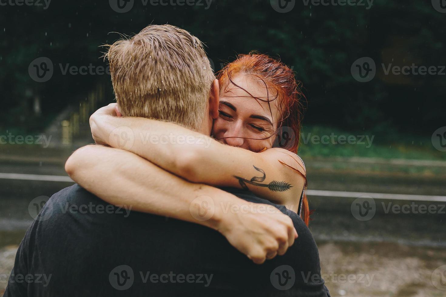 beautiful couple hugging in the rain photo