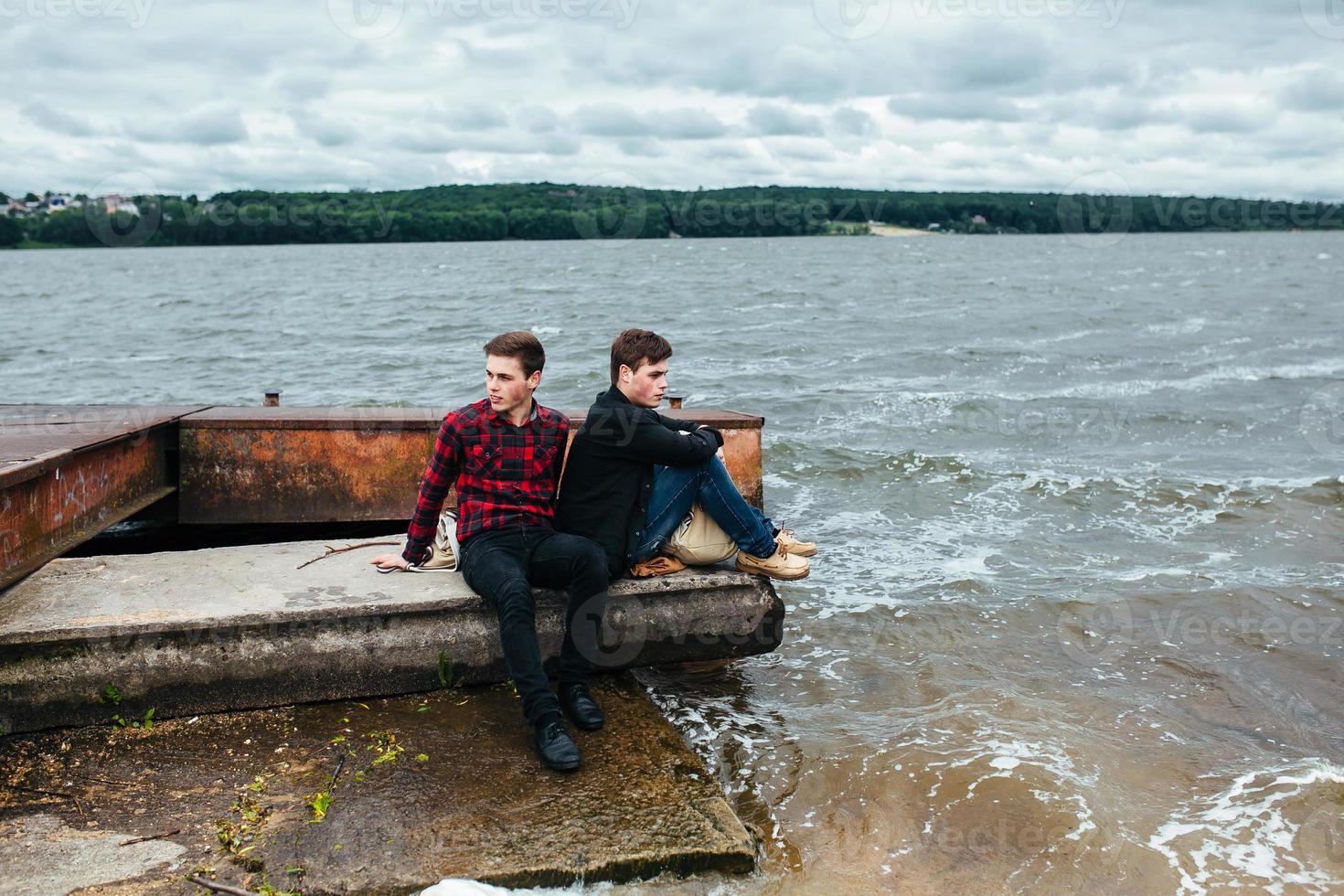 Two friends relaxing on the pier. photo