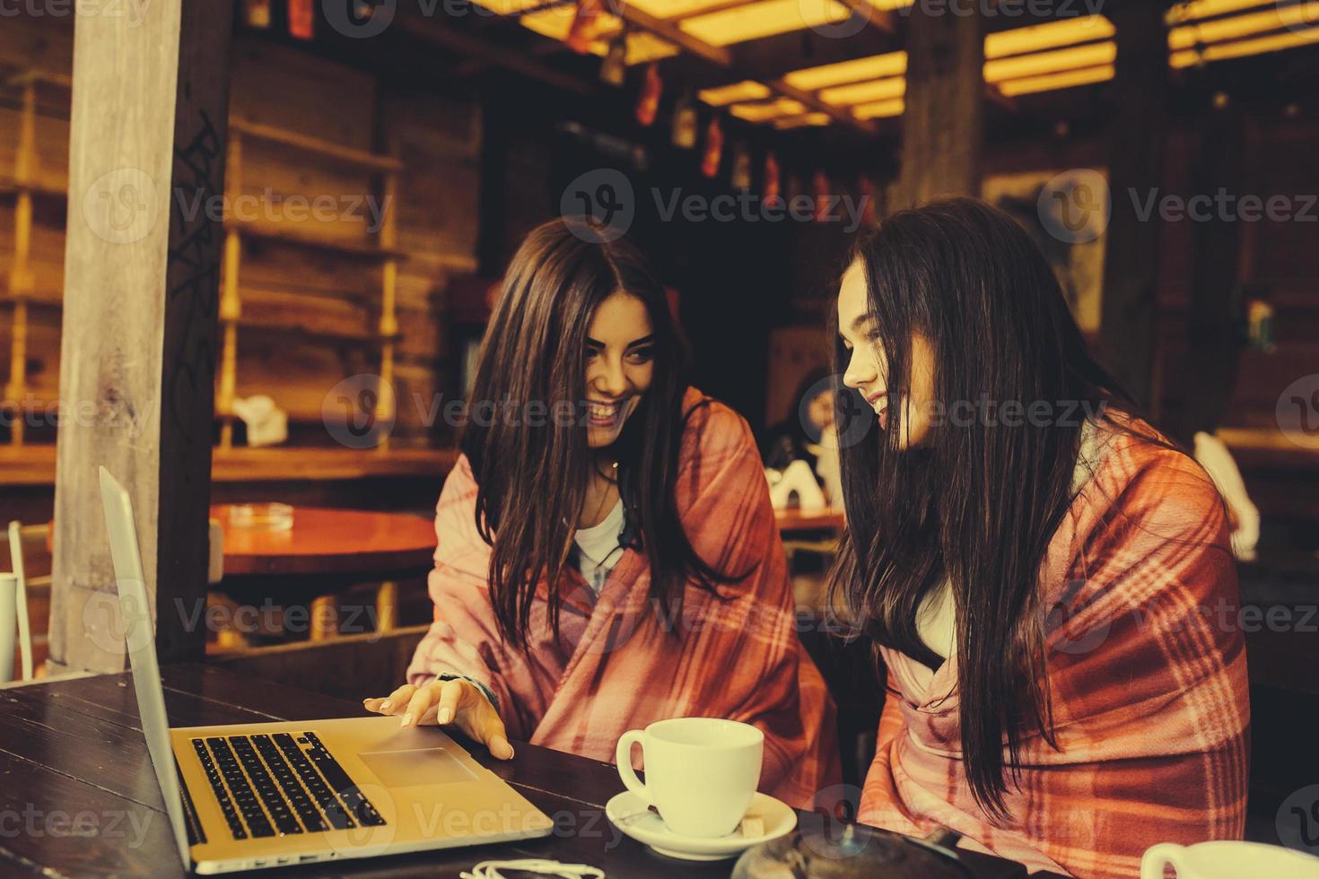 dos chicas viendo algo en la computadora portátil foto