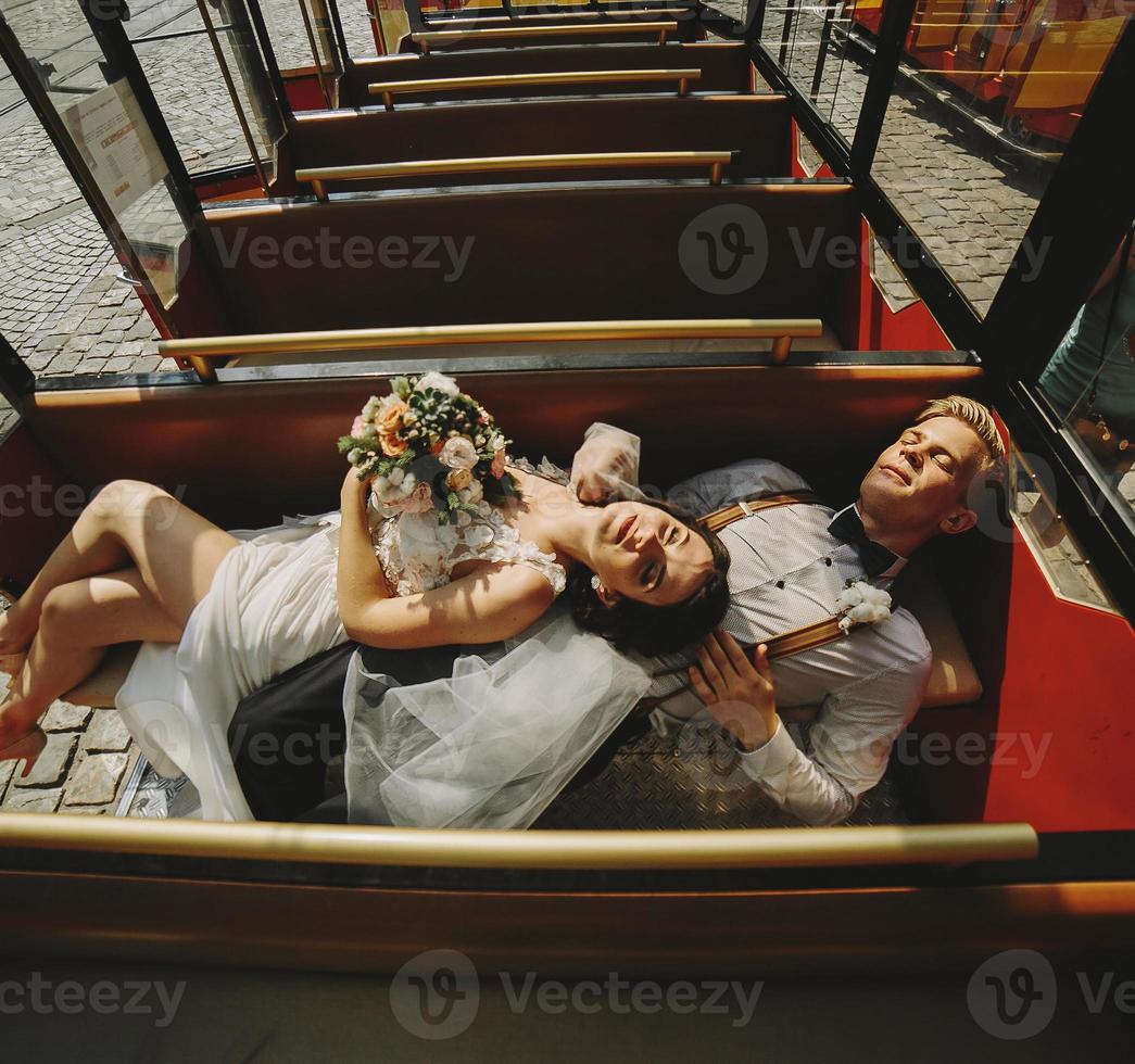 Bride and groom posing in a tour car photo
