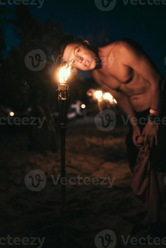 Guy with torchlight on the beach at night photo