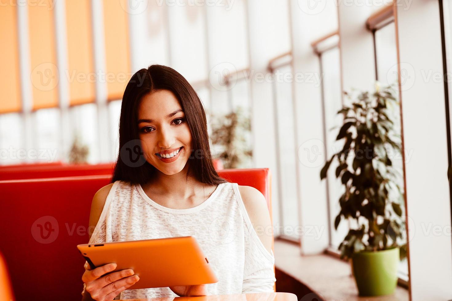 Beautiful girl working on a tablet and smiling.  Instagram toning effect photo
