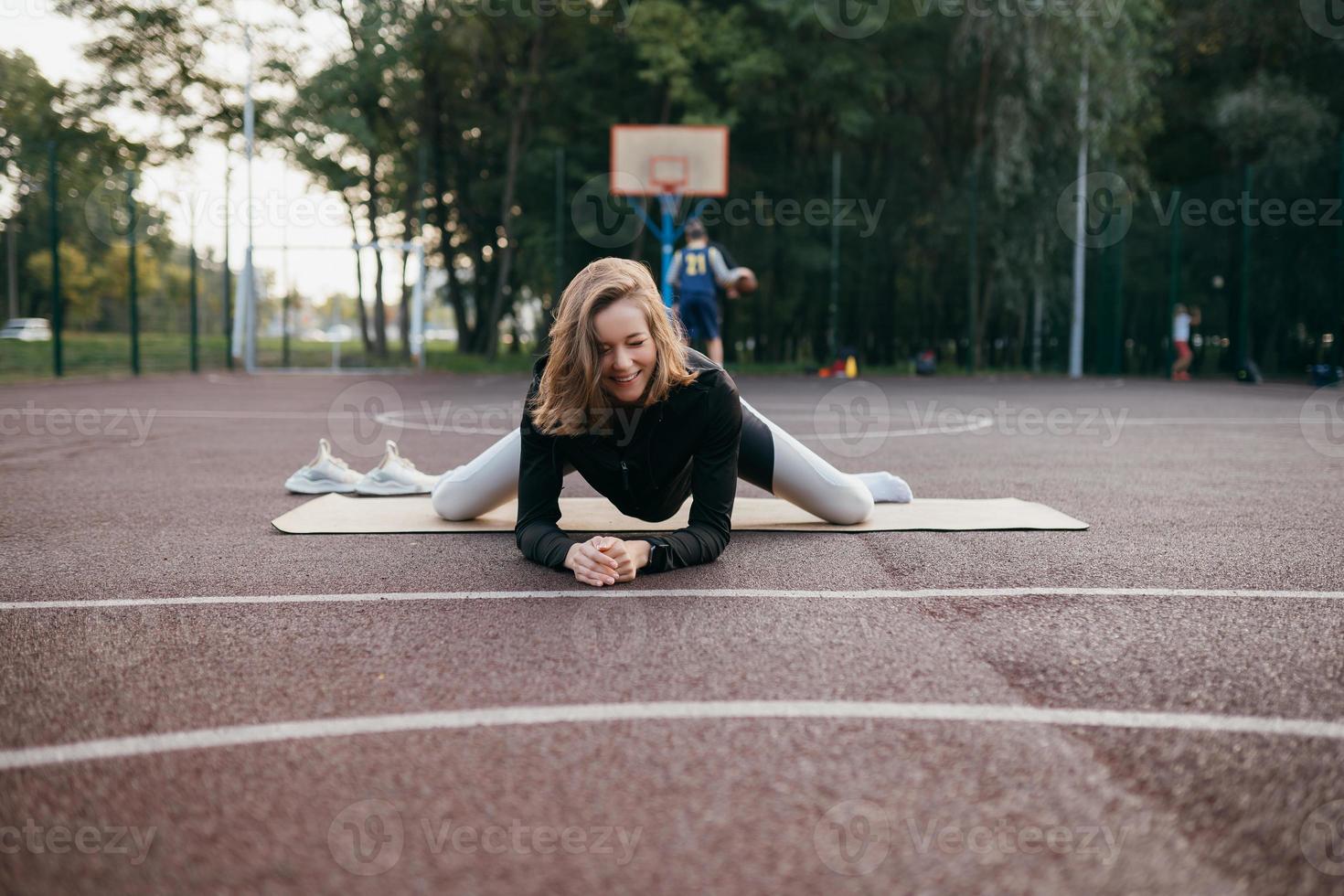 Young fit woman in sportswear trains outdoors on the playground. photo