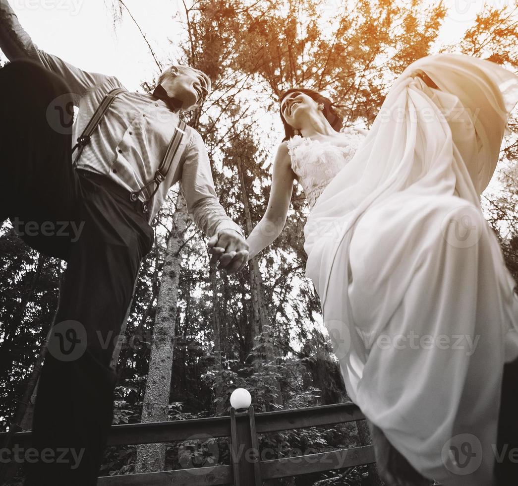 bride and groom jumping, having fun photo