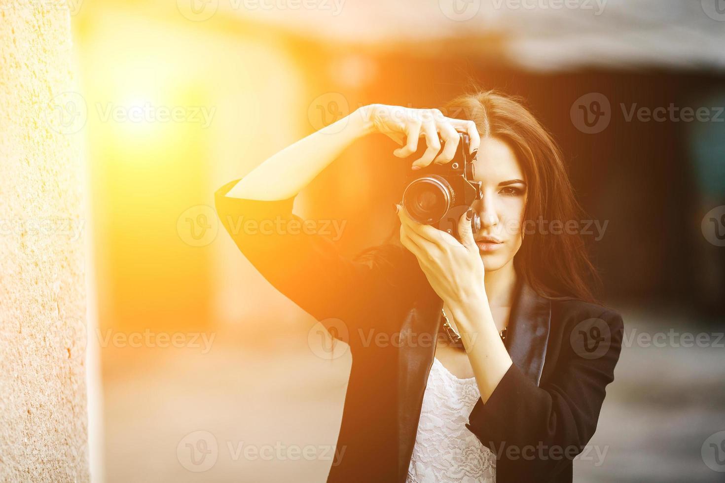 Beautiful female photographer posing with camera photo