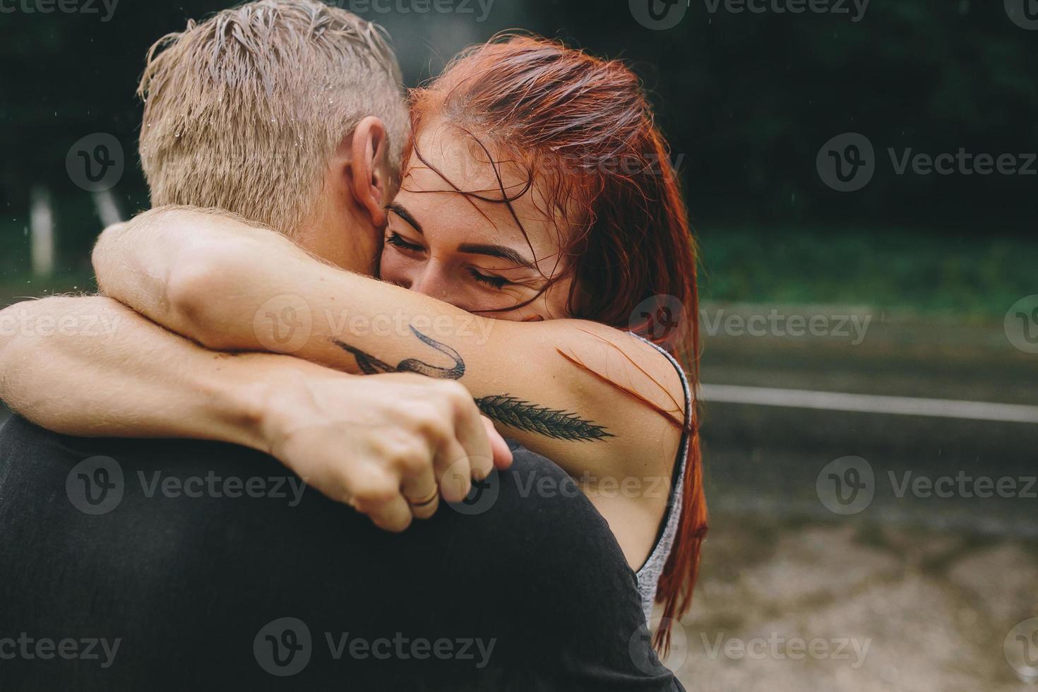 beautiful couple hugging in the rain photo