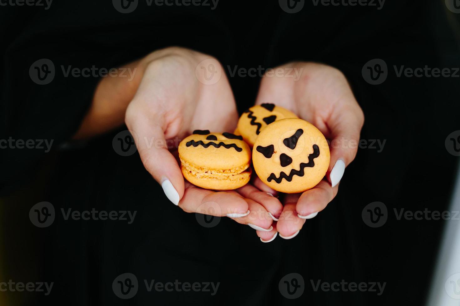 mujer sosteniendo una galleta para halloween foto