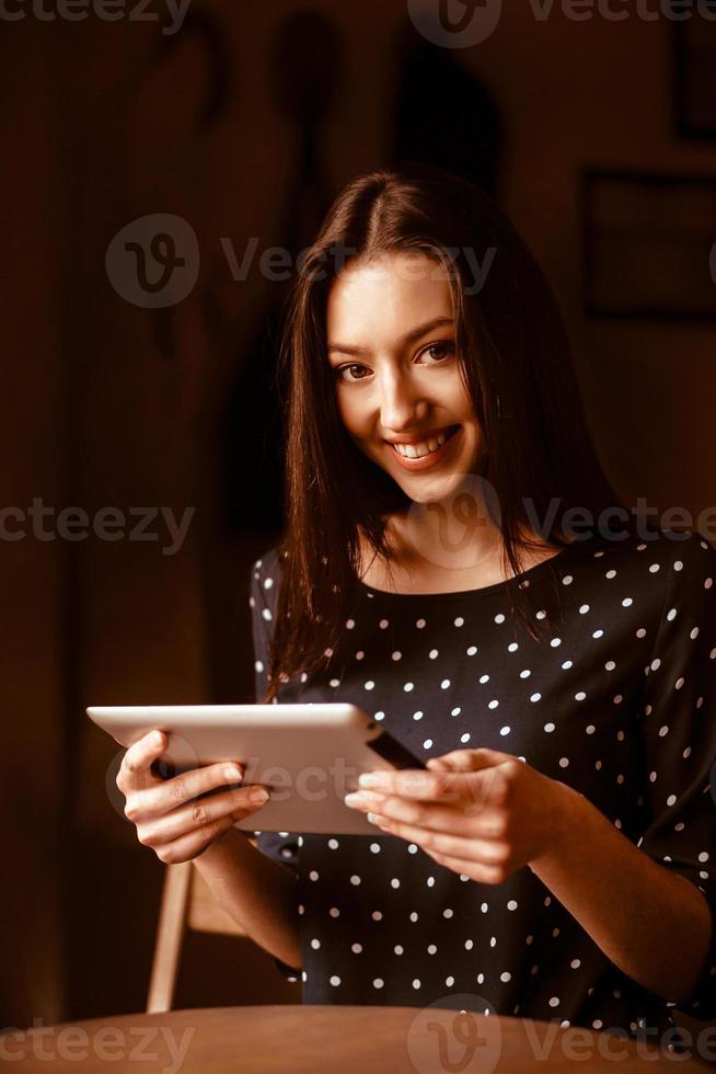 Beautiful girl working on a tablet and smiling.  Instagram toning effect photo