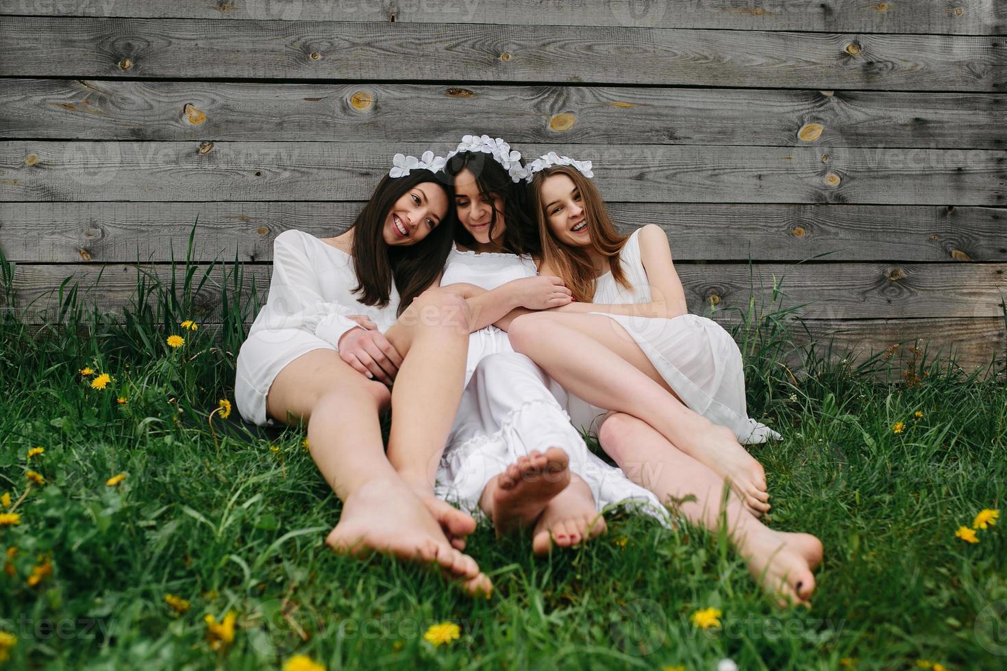 tres chicas encantadoras cerca de una casa de madera foto