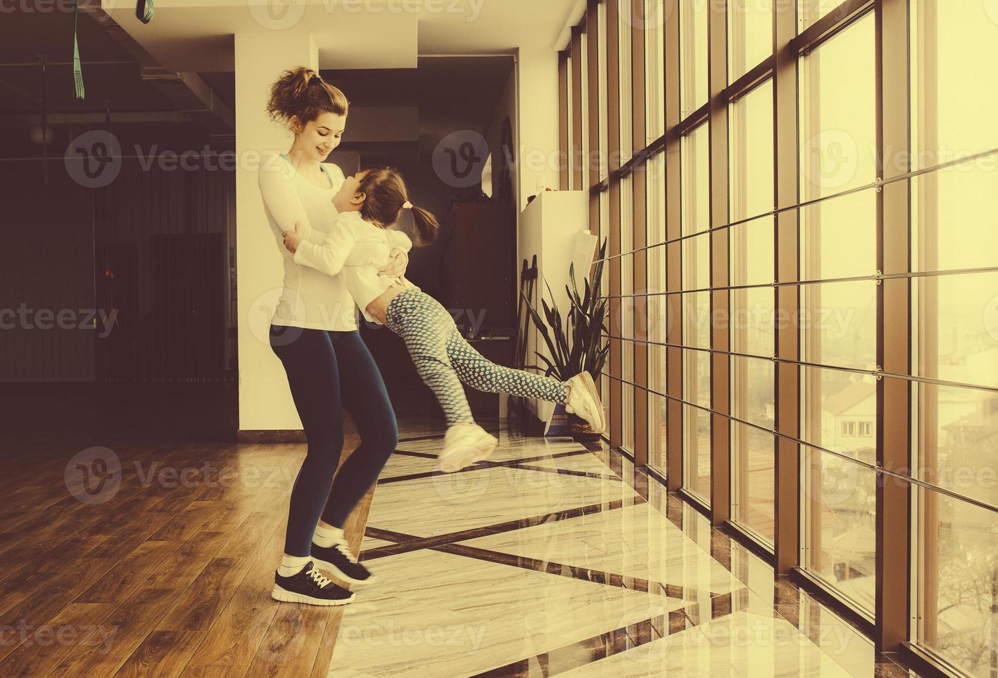 Mother twist her daughter in the gym photo