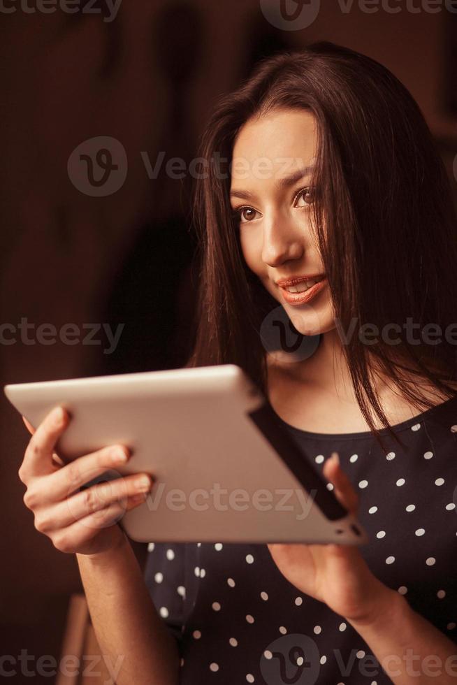 Beautiful girl working on a tablet and smiling.  Instagram toning effect photo