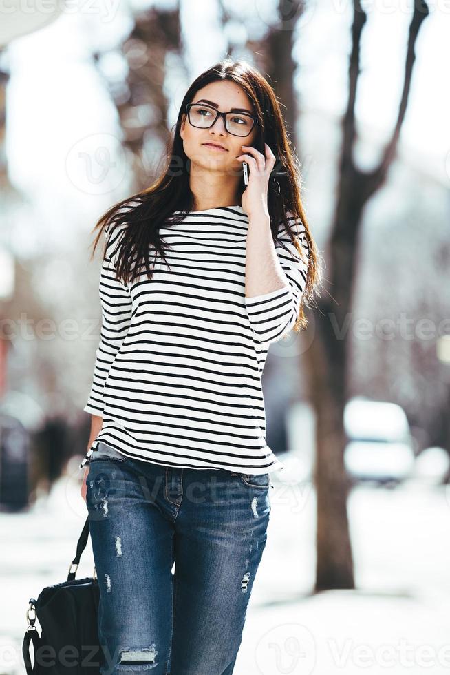 Beautiful model walks with phone photo