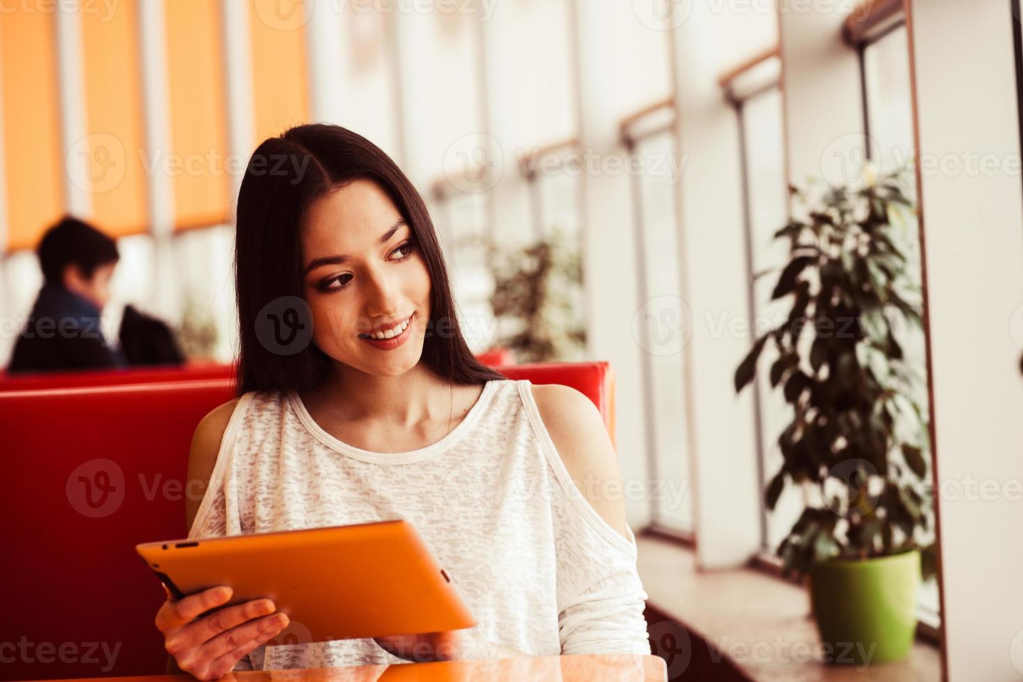 Beautiful girl working on a tablet and smiling.  Instagram toning effect photo