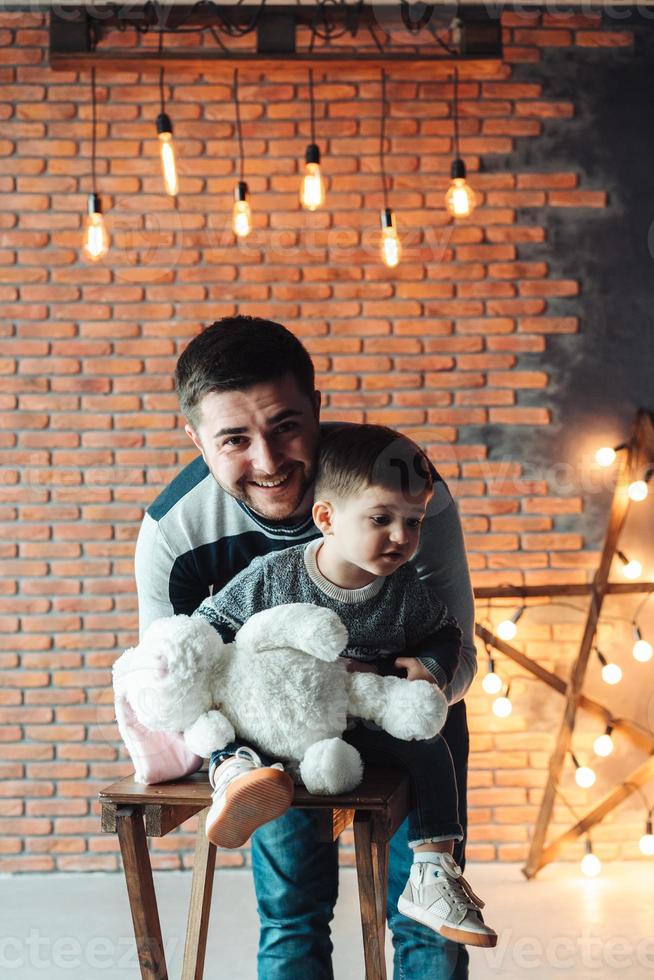 Dad and son on a background of a brick wall photo