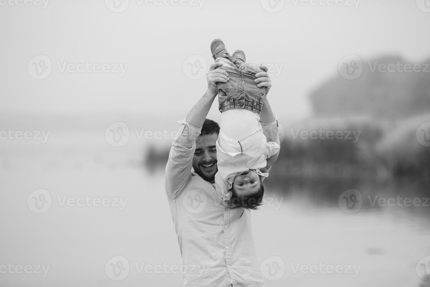 papá sosteniendo a su hijo por los pies foto